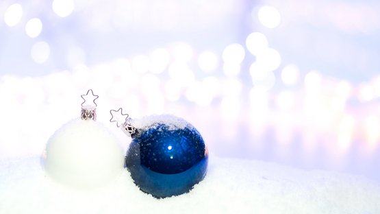 Eine weiße und eine blaue Christbaumkugel vor einem weißen Hintergrund