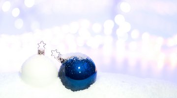 Eine weiße und eine blaue Christbaumkugel vor einem weißen Hintergrund