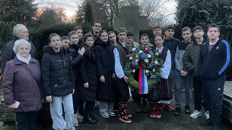 ein Gruppenfoto mit allen Beteiligten. Zu sehen sind die Jugendlichen und die Betreuenden. Alle schauen in die Kamera. In der Mitte ist der Kranz zu sehen.