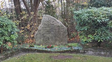 Ein Gedenkstein mit der Inschrift: „Hier ruhen gefallene Soldaten und uns Leben gekommene ausländische Zivilisten des Krieges 1939–1945.“ 