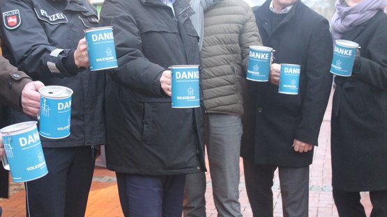 Mehrere Personen halten die blauen Volksbund Sammeldosen in die Kamera. Darauf ist das Volksbundlogo und der Schriftzug „Danke“ zu erkennen. Die Gesichter der Personen sind nicht zu sehen.